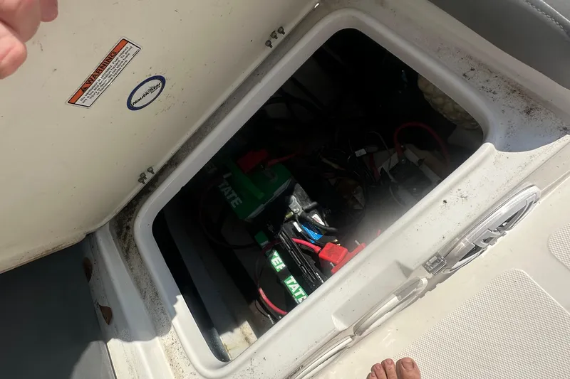 Slide: The Image of 2023 NauticStar 2102 Legacy boat battery compartment with visible wiring and components. - 22