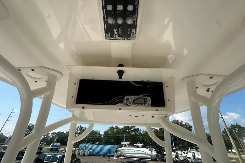 Slide: The Image of 2023 NauticStar 2102 Legacy boat console with electronic controls and storage compartment. - 24