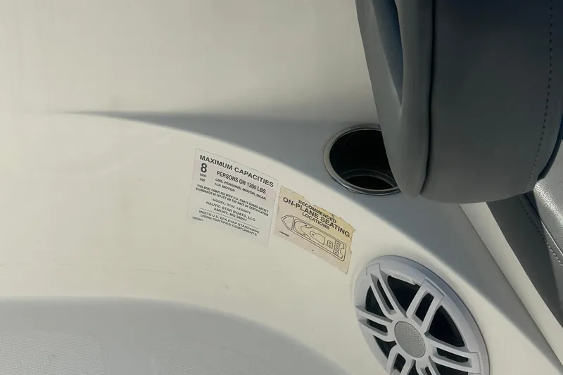 Slide: The Image of 2023 NauticStar 2102 Legacy boat interior with capacity label and speaker detail. - 26