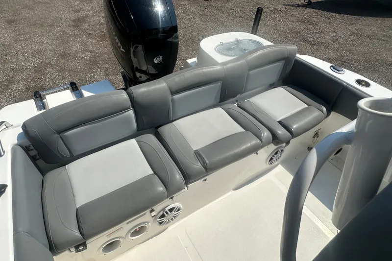 Slide: The Image of 2023 NauticStar 2102 Legacy boat with gray cushioned seating and outboard motor. - 27