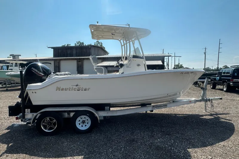 Slide: The Image of 2023 NauticStar 2102 Legacy boat on trailer, parked outdoors under clear sky. - 5