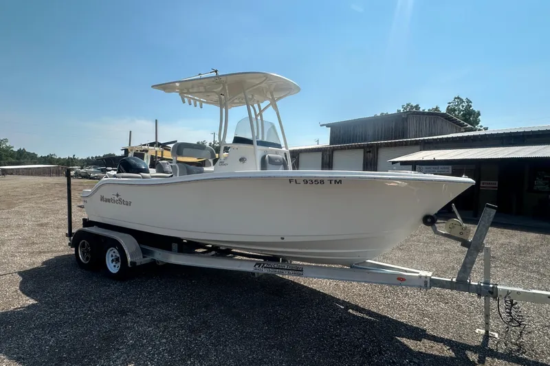 Slide: The Image of 2023 NauticStar 2102 Legacy boat on trailer, parked outdoors under clear sky. - 6