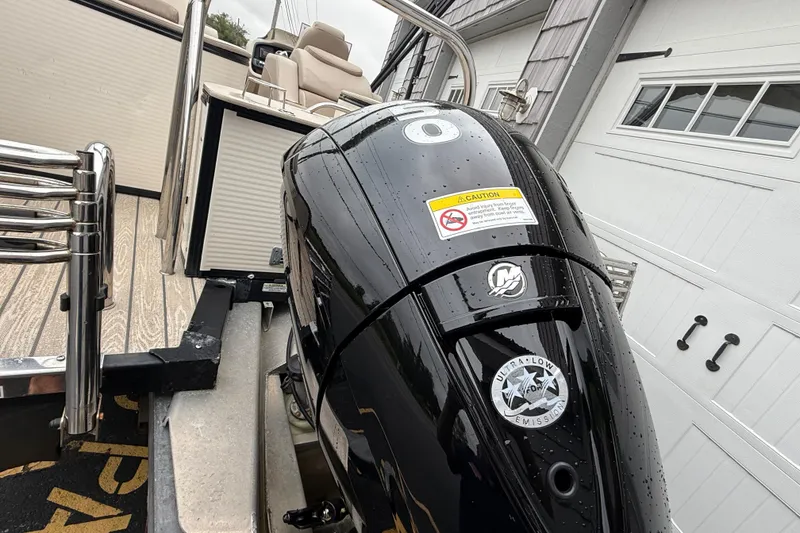 Slide: The Image of 2018 Avalon 2385 Catalina Rear Lounger with powerful outboard motor, wet from rain. - 10