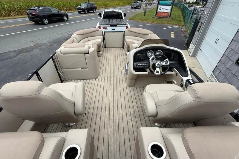 Slide: The Image of 2018 Avalon 2385 Catalina Rear Lounger Tri-Toon boat with beige seating and modern dashboard. - 15