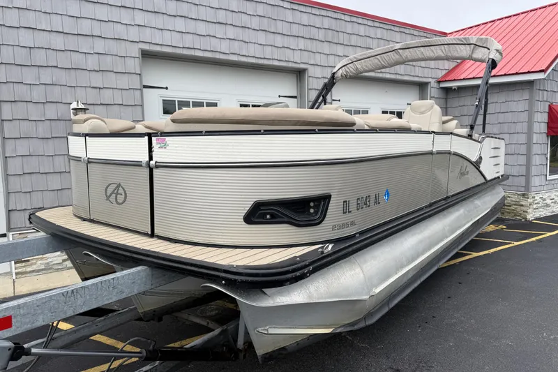 Slide: The Image of 2018 Avalon 2385 Catalina Rear Lounger Tri Toon boat on trailer, parked outside. - 3