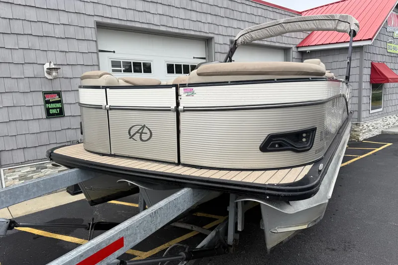 Slide: The Image of 2018 Avalon 2385 Catalina Rear Lounger Tri Toon boat on trailer, parked outside. - 4