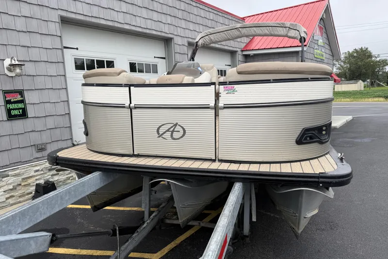 Slide: The Image of 2018 Avalon 2385 Catalina Rear Lounger Tri Toon on trailer, parked outside building. - 5