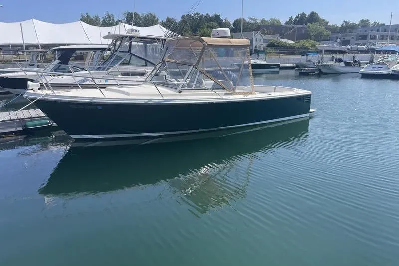 The Image of 2004 Limestone 24 boat docked in a marina, featuring a sleek design and clear canopy. - 1