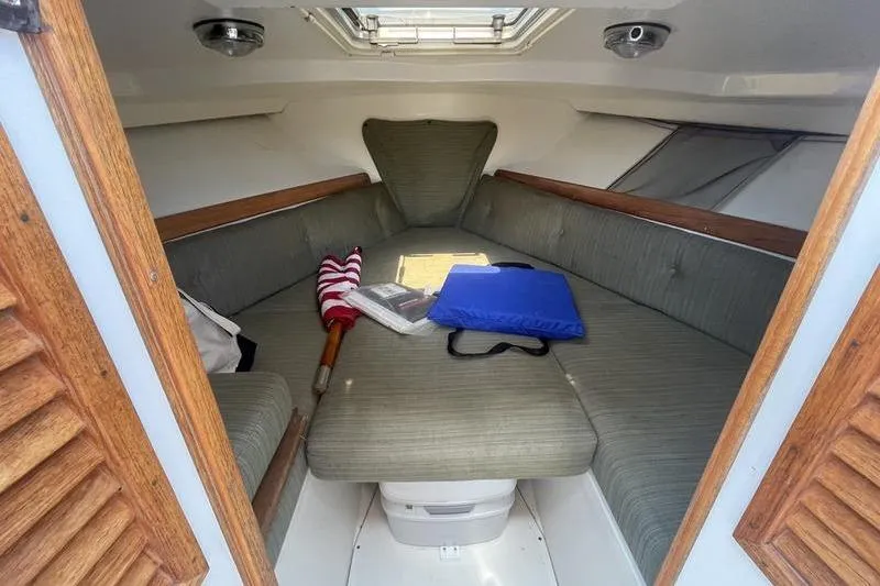 Slide: The Image of Interior cabin of a 2004 Limestone 24 boat with cushioned seating and wooden accents. - 12