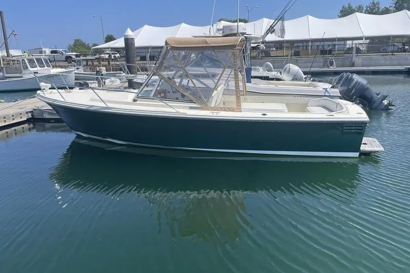 Slide: The Image of 2004 Limestone 24 boat docked in marina, featuring a sleek design and canopy. - 4