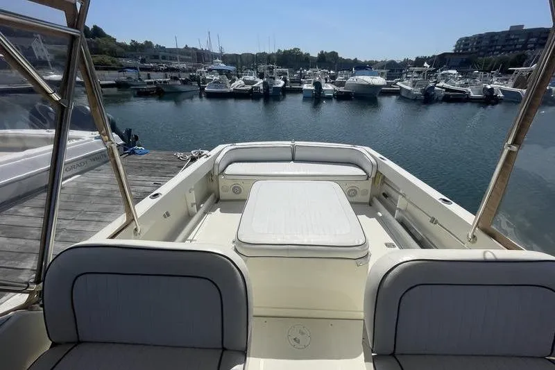 Slide: The Image of 2004 Limestone 24 boat interior at marina, featuring spacious seating and calm waters. - 8
