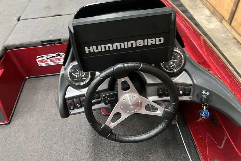 Slide: The Image of 2014 Skeeter ZX 190 boat dashboard with Humminbird display and steering wheel. - 2