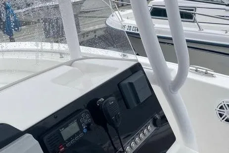 Slide: The Image of 2020 Tidewater 220 CC boat console with navigation equipment and controls at a marina. - 6