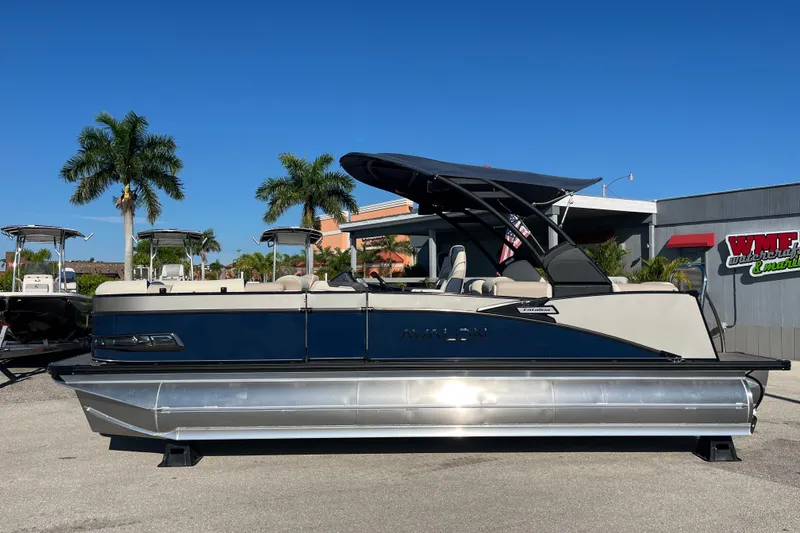 Slide: The Image of 2026 Avalon 2385 Catalina Quad Lounger Tri Toon boat, parked outdoors under clear blue sky. - 8