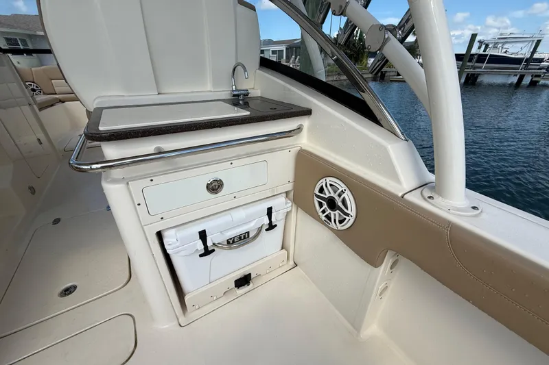 Slide: The Image of 2023 Scout 255 Dorado boat interior with sink, Yeti cooler, and speaker. - 15