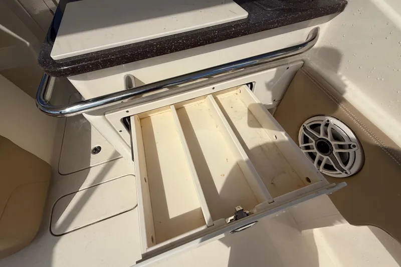 Slide: The Image of 2023 Scout 255 Dorado boat interior with open storage compartment and speaker. - 18