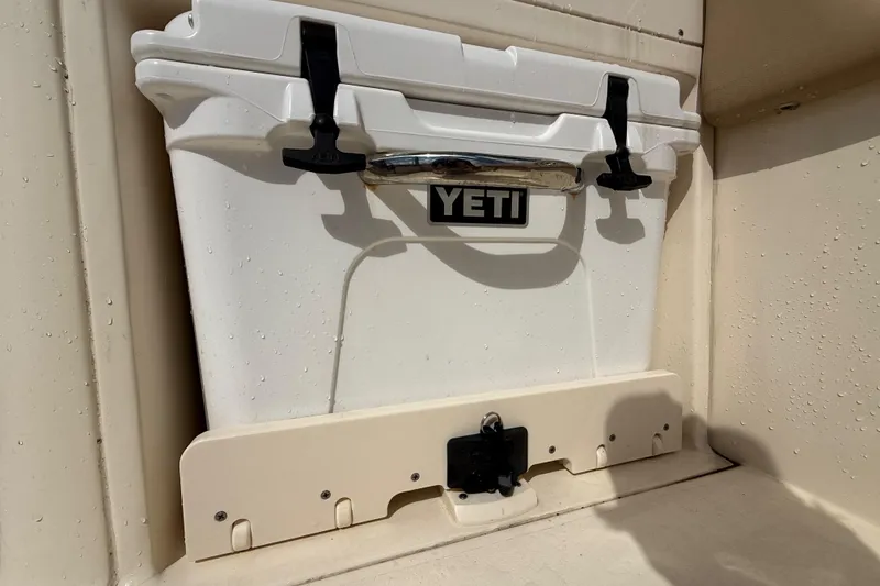 Slide: The Image of YETI cooler on 2023 Scout 255 Dorado boat, secured with black latches. - 19