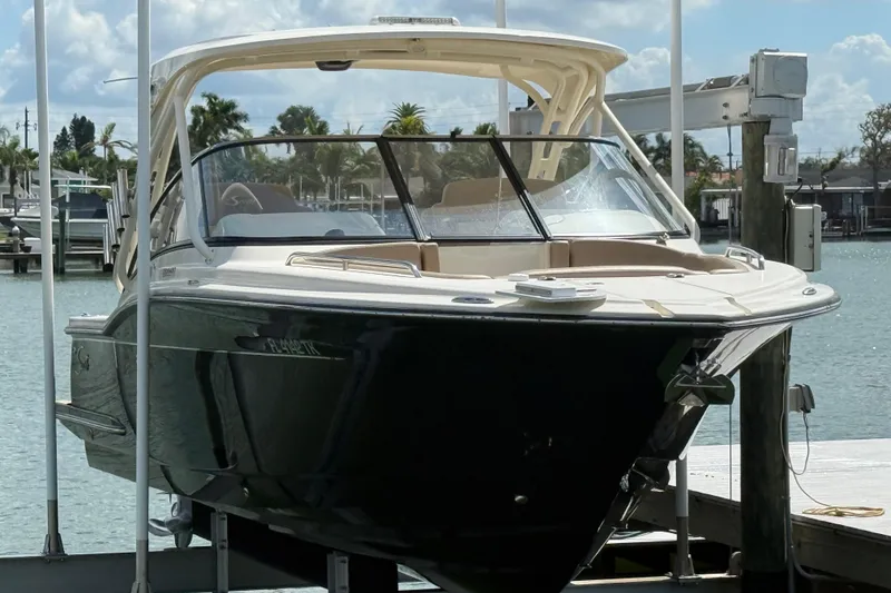 Slide: The Image of 2023 Scout 255 Dorado boat docked at marina, sunny day, calm water. - 2