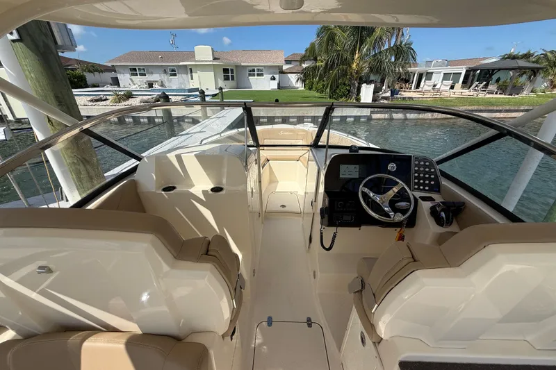 Slide: The Image of 2023 Scout 255 Dorado boat interior with helm, seating, and waterfront view. - 25