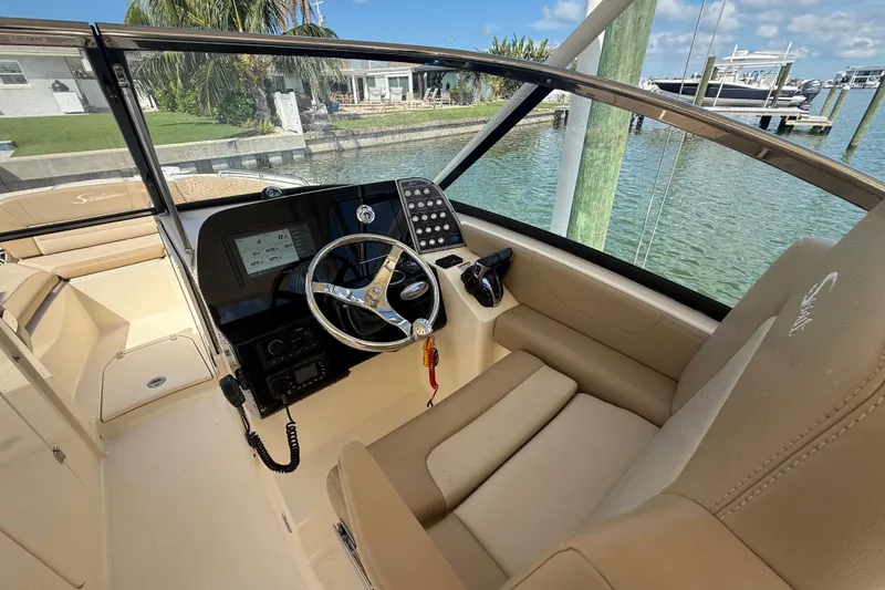 Slide: The Image of 2023 Scout 255 Dorado boat cockpit with steering wheel and control panel. - 26