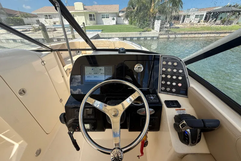 Slide: The Image of 2023 Scout 255 Dorado boat dashboard with steering wheel and control panel. - 27