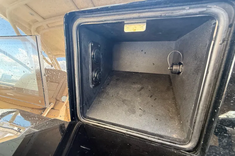 Slide: The Image of 2023 Scout 255 Dorado storage compartment with electronic controls and water droplets. - 29