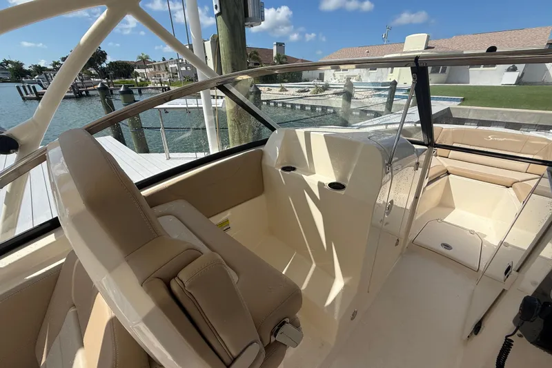 Slide: The Image of 2023 Scout 255 Dorado boat interior with beige seating and waterfront view. - 34