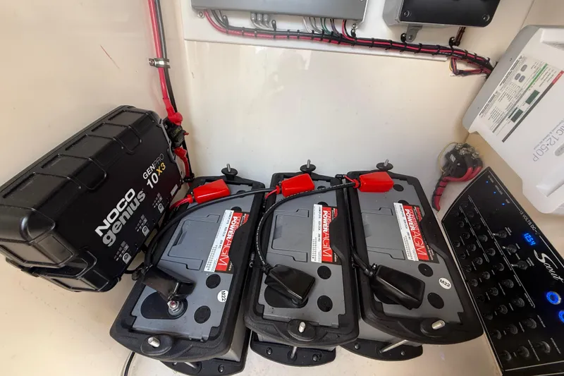 Slide: The Image of 2023 Scout 255 Dorado boat battery compartment with Noco Genius charger and Power AGM batteries. - 38