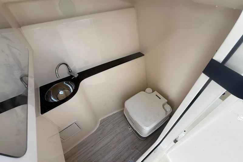 Slide: The Image of 2023 Scout 255 Dorado boat interior with compact bathroom, sink, and portable toilet. - 41