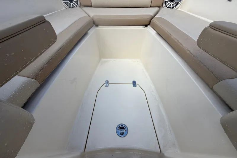 Slide: The Image of 2023 Scout 255 Dorado boat interior with cushioned seating and storage compartment. - 46