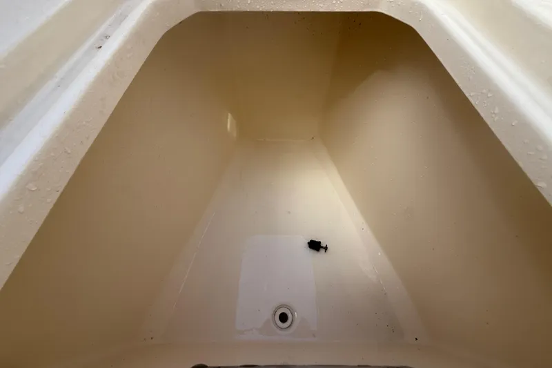 Slide: The Image of Storage compartment of 2023 Scout 255 Dorado boat, featuring drainage and clean interior. - 48