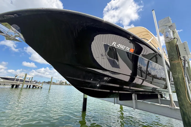 Slide: The Image of 2023 Scout 255 Dorado boat on lift, reflecting water and sky. - 5