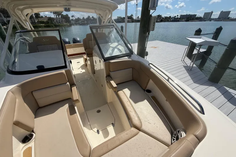 Slide: The Image of 2023 Scout 255 Dorado boat interior with beige seating, docked by the water. - 63