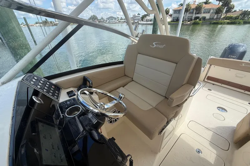 Slide: The Image of 2023 Scout 255 Dorado boat interior with steering wheel and beige seating. - 67