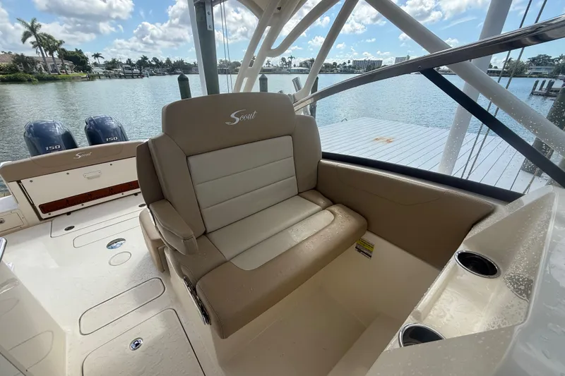 Slide: The Image of 2023 Scout 255 Dorado boat interior with seating and twin engines, docked by the water. - 68