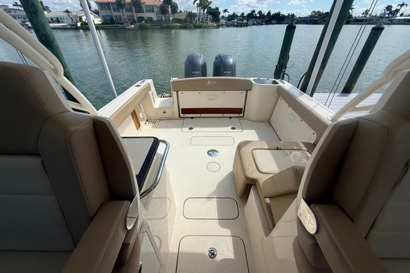 Slide: The Image of 2023 Scout 255 Dorado boat interior with seating and twin engines, docked by the water. - 69