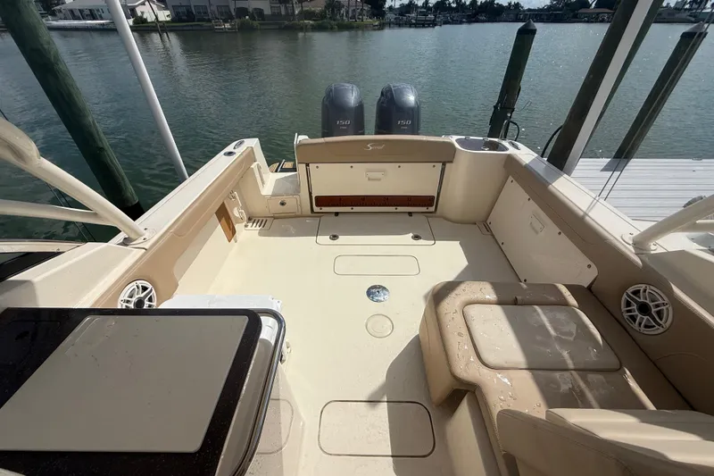 Slide: The Image of 2023 Scout 255 Dorado boat interior with seating and twin engines, docked by the water. - 70