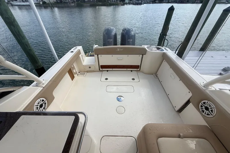 Slide: The Image of 2023 Scout 255 Dorado boat deck with twin engines, docked by the water. - 71