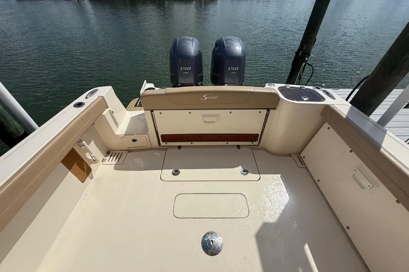 Slide: The Image of 2023 Scout 255 Dorado boat deck with twin 150 engines, docked by the water. - 72