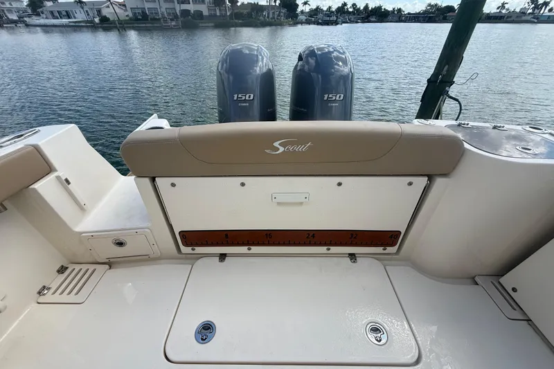 Slide: The Image of 2023 Scout 255 Dorado boat with dual Yamaha 150 engines on a calm waterfront. - 73