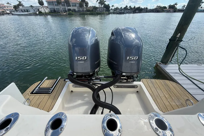 Slide: The Image of 2023 Scout 255 Dorado boat with dual Yamaha 150 engines docked by the water. - 81