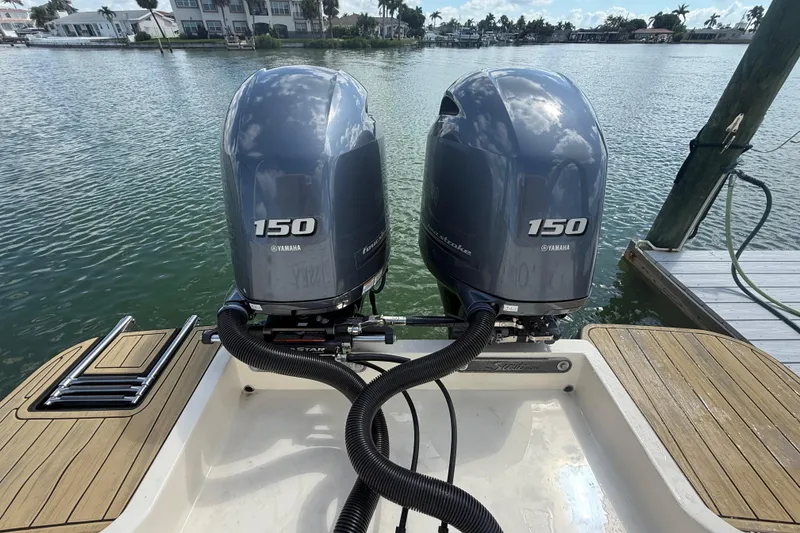 Slide: The Image of 2023 Scout 255 Dorado with twin Yamaha 150 engines docked by the water. - 82