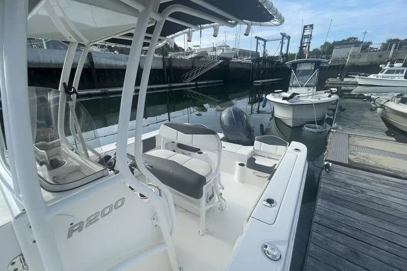 Slide: The Image of 2020 Robalo R200 boat docked, featuring seating and console, in a marina setting. - 3