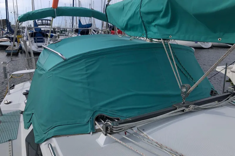 Slide: The Image of 1996 Catalina 36 MkII sailboat with teal canvas cover in marina setting. - 12
