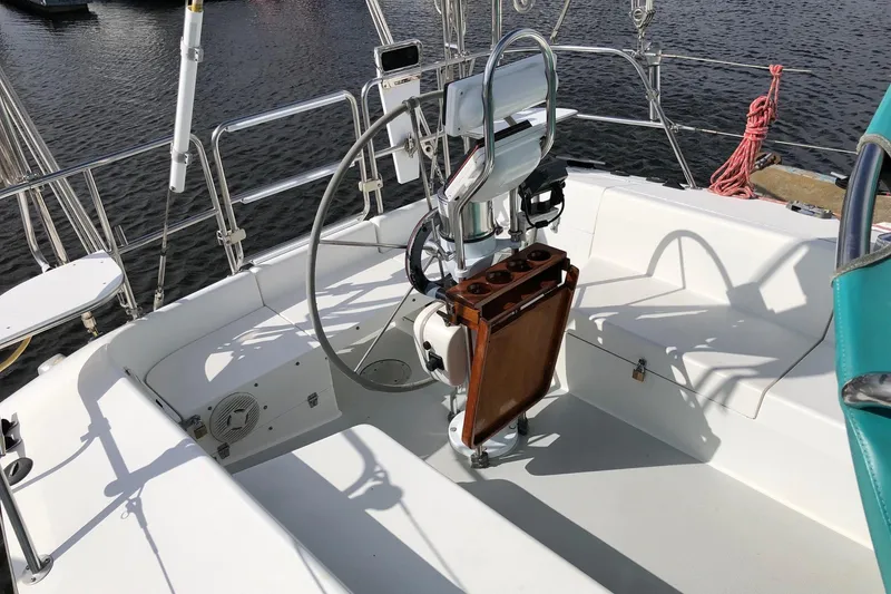 Slide: The Image of Cockpit of 1996 Catalina 36 MkII sailboat with steering wheel and seating, docked by water. - 13