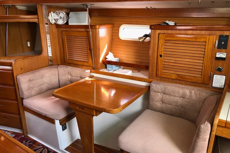 Slide: The Image of Interior of a 1996 Catalina 36 MkII sailboat with wooden dining area and cushioned seating. - 2