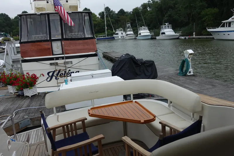 Slide: The Image of 2007 Chris-Craft Roamer 40 yacht docked, featuring a cozy seating area with a wooden table. - 11