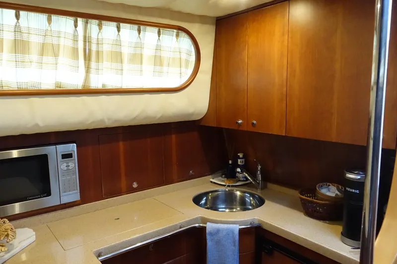 Slide: The Image of Luxurious kitchen interior of 2007 Chris-Craft Roamer 40 yacht with wood cabinetry and modern appliances. - 14