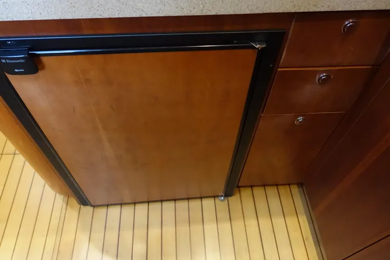 Slide: The Image of Wooden cabinetry and Dometic fridge in 2007 Chris-Craft Roamer 40 yacht interior. - 17