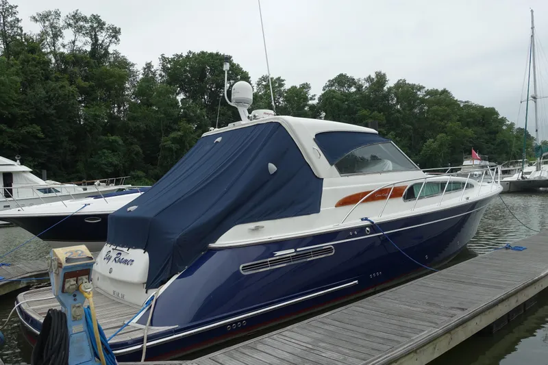 Slide: The Image of 2007 Chris-Craft Roamer 40 yacht docked, featuring sleek design and blue cover. - 2